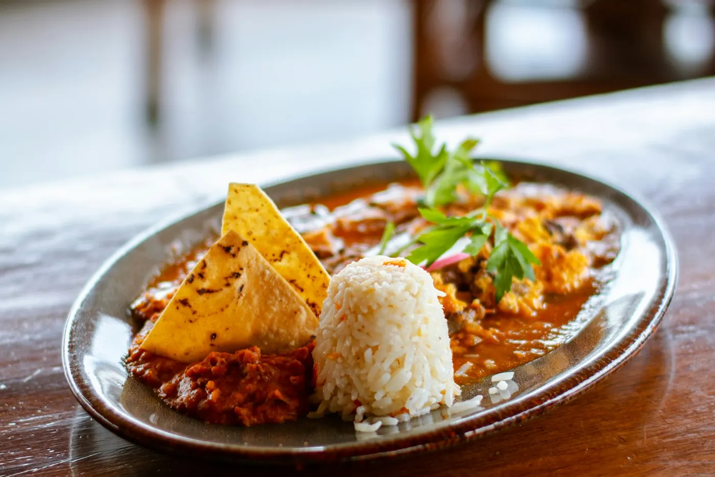 Guisado con arroz, frijoles y totopos servido en un comedor