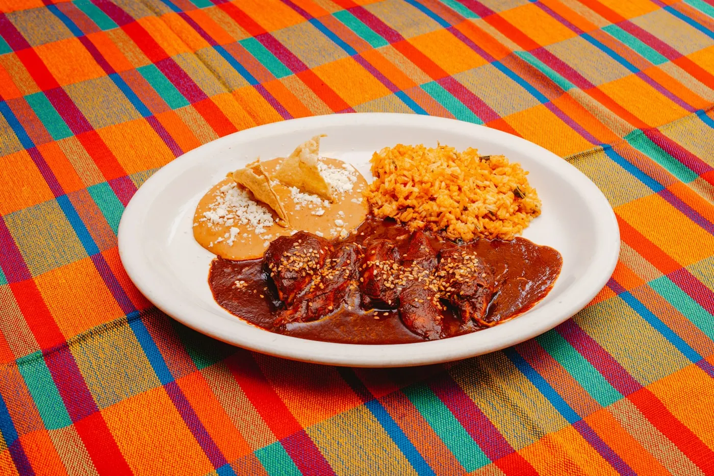 Plato de mole con arroz sobre un mantel de colores